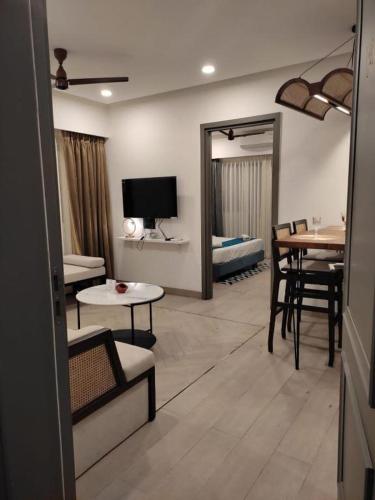 uma sala de estar com televisão e uma sala de jantar em Kudrat Paradise - Full Villa By AP Villas em Indore