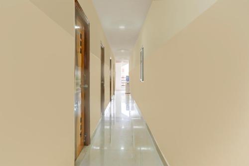 ハイデラバードにあるSuper Collection O Sri Balaji Luxury roomsの白壁と長白床の空廊