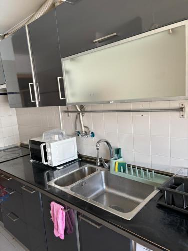 uma cozinha com um lavatório e um micro-ondas em Ranjeet felizarda em Lisboa