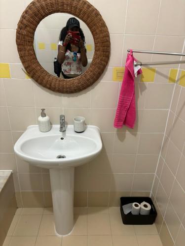 a woman taking a picture of a sink in a bathroom at Ranjeet felizarda in Lisbon