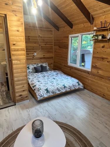 een slaapkamer in een blokhut met een bed bij Cabana Sorina in Corbu