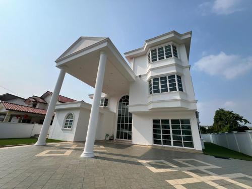 a large white house with pillars in front of it at DeGarden House Klang in Klang