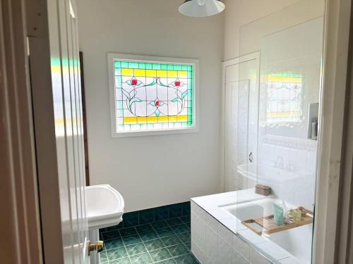 a bathroom with a white sink and a window at Home in Lamington in Kalgoorlie