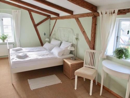 een slaapkamer met een wit bed en een stoel bij Countryside holiday home near bus stop in Hattlund