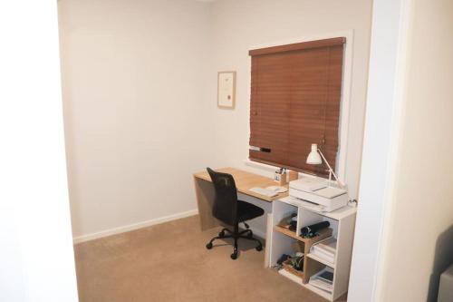 an office with a desk with a chair and a window at Home in Lamington in Kalgoorlie