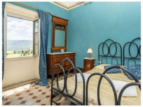 1 dormitorio con cama con espejo y ventana en Villa Rignano Comfortable holiday residence, en Rignano sullʼArno