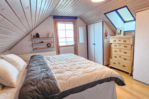 ein Schlafzimmer mit einem großen Bett im Dachgeschoss in der Unterkunft Fiskarvillan in Simrishamn