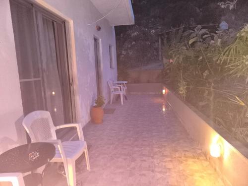 a room with chairs and tables and a balcony at Mary's house in Kyparíssion