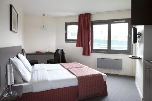 a hotel room with a bed and a window at Villa Bellagio Villejuif by Popinns in Villejuif