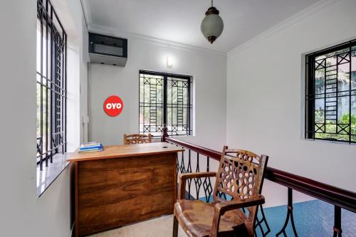 un bureau avec un bureau et deux chaises dans l'établissement OYO Kakkanad Heights Inn, à Kakkanad