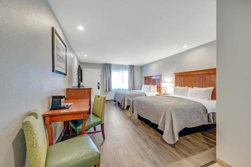 um quarto de hotel com duas camas e uma secretária em Quality Inn em Santa Cruz