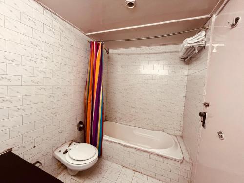 e bagno con servizi igienici, vasca e lavandino. di Ramayan Resort, in City Centre Manali By Ramanand Sagar a Manāli