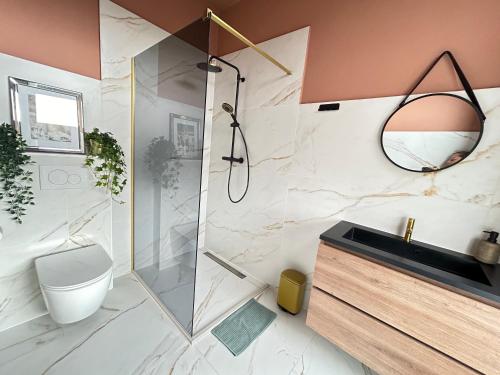 a bathroom with a shower and a toilet and a sink at Lovely Spacious Apartment in Zandvoort