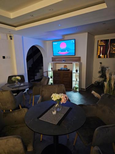 sala de estar con sofás y TV en la pared en Pensiunea Miruna, en Moieciu de Jos
