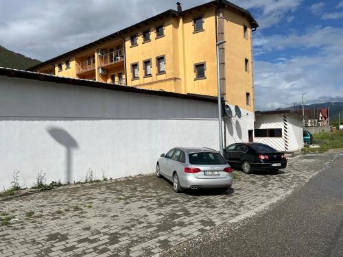 two cars parked in a parking lot in front of a building at SARAH APARTMENTS in Gusinje