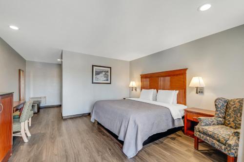 a hotel room with a bed and a chair at Quality Inn Santa Cruz Downtown Area in Santa Cruz