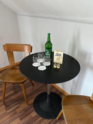 - une table noire avec une bouteille de vin et des verres dans l'établissement Hotel Krone Uetendorf, à Uetendorf