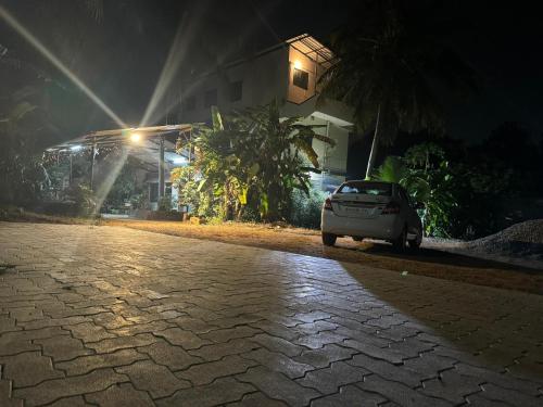 a car parked on a cobblestone street at night at KENSON HOMESTAY in Mangalore