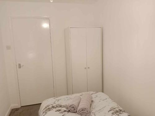 a bedroom with white walls and a bed with towels at Monmouth House Aylesbury Premier Quality Accommodation For Larger Families Contractors And Professionals Sleeps Up to 6 Guests in Buckinghamshire