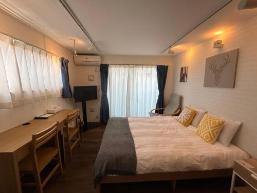 a hotel room with a bed and a desk at 湘南海岸 可见海景 江之岛旅游推荐住宿 独立房源 带卫生间、厨房 近海滩 海景房 in Fujisawa