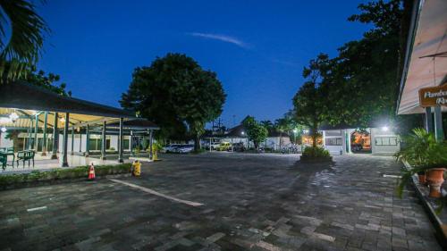 a parking lot in front of a building at night at Royal Brongto Hotel in Timuran