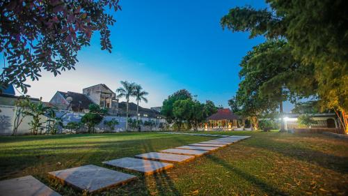 a walkway in the middle of a grass field at Royal Brongto Hotel in Timuran