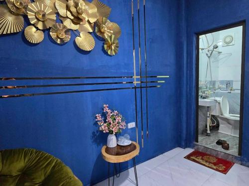 a blue room with a vase of flowers on a table at alley homestay in Hanoi