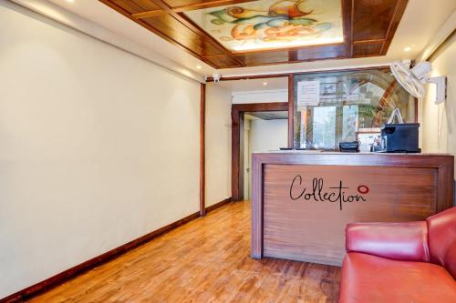 a restaurant with a counter and a red couch at Collection O Hotel Nanashree Grand in Pune