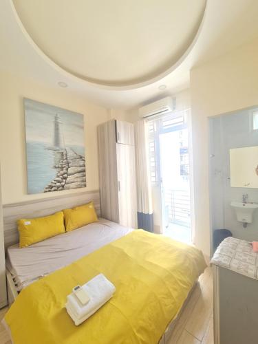 The HogWarts Hostel في مدينة هوشي منه: غرفة نوم بسرير كبير مع شراشف صفراء