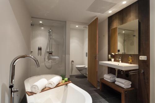 La salle de bains est pourvue d'une baignoire, d'un lavabo et de toilettes. dans l'établissement Van Heeckeren Hotel, à Nes