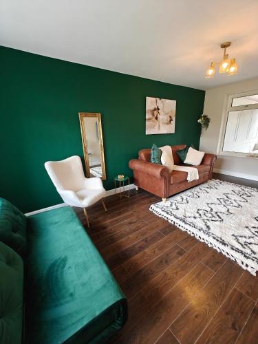 a living room with a couch and a chair at Under 10 Mins to NEC BHX - Walk to JLR -2 Large Living Areas - 4 Bedroom Spacious Home - Van Parking x2 - 5 Beds Excellent Equipped Home - NR A45 Solihull Bypass M42 HS2 Works in Solihull
