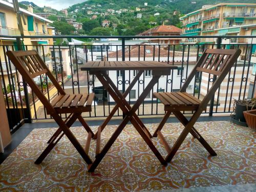 Una mesa de madera y dos sillas en un balcón. en Casa di Roby, en Rapallo