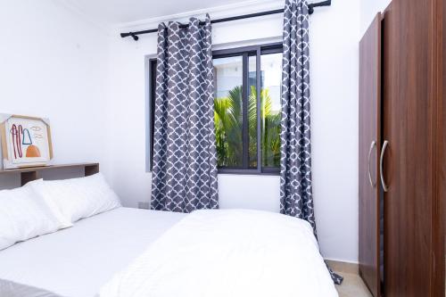 a bedroom with a bed and a window with curtains at Stay Play Away Residences - Luxury 5 bed, Airport Residential in Accra