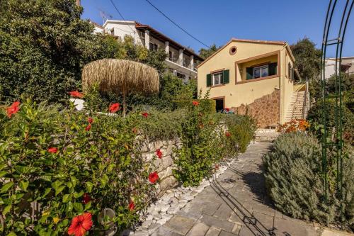 a house with a garden with flowers in front of it at Villa Edem in Kassiopi