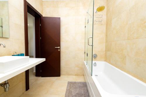 a bathroom with a tub and a sink and a shower at Stay Play Away Residences - Luxury 5 bed, Airport Residential in Accra
