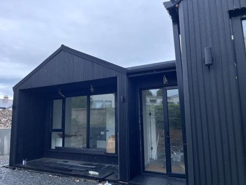 a black building with glass windows on the side at Deerpark luxury 3 bed retreat in Cashel