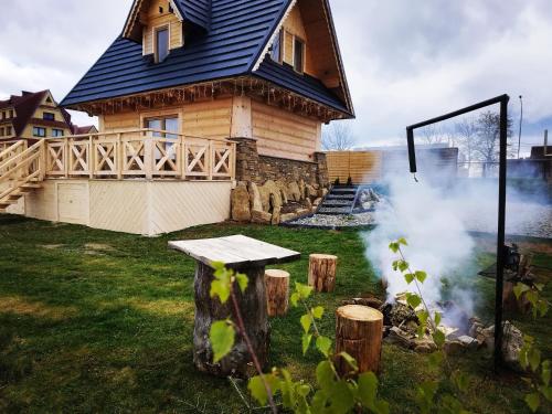 a wooden house with a smoke stack in front of it at Zymbiańsko Chałupa 2 z jacuzzi in Ząb