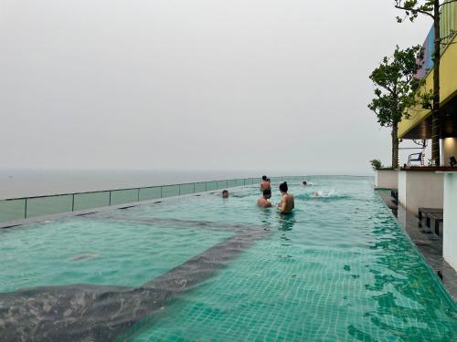 a group of people in a swimming pool near the ocean at Flamingo Hải Tiến in Thanh Hóa