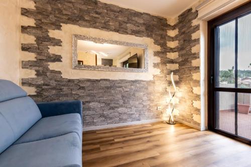 a living room with a stone wall with a mirror at Verdemare in Duino