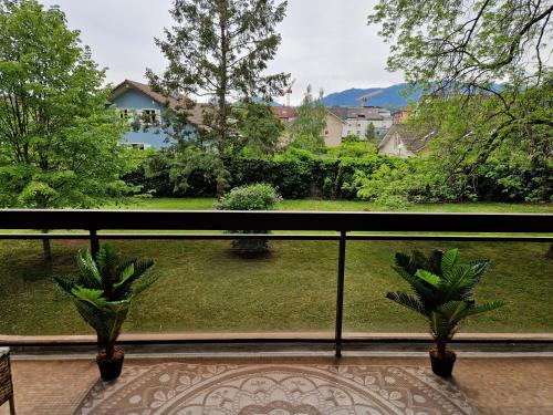 een balkon met uitzicht op een tuin en 2 planten bij Charmant studio au calme in Thonon-les-Bains