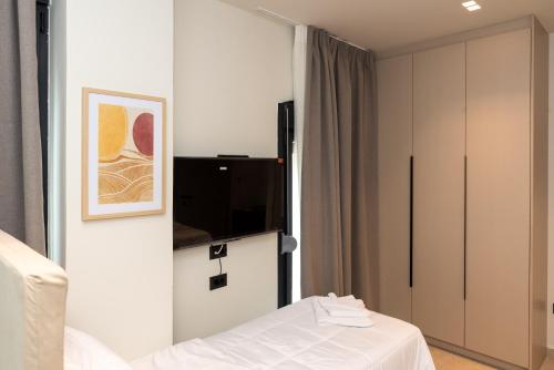 Cette chambre comprend un lit et une télévision. dans l'établissement Tokyo Studios, à Chios