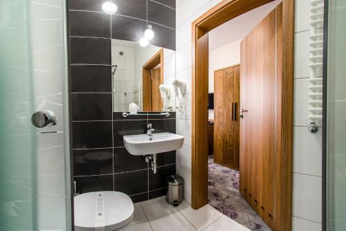 a bathroom with a sink and a toilet at Hotel Polonia in Biała Podlaska
