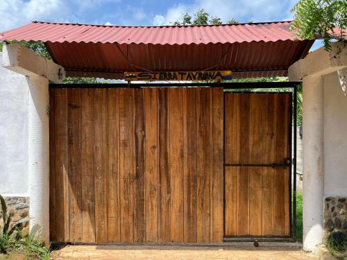 une porte de garage en bois munie d'un panneau. dans l'établissement Sierra Tayrona hostel, à El Zaino