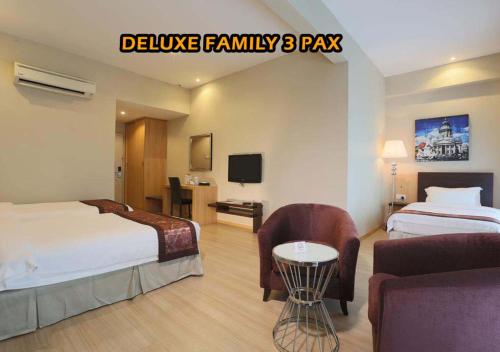 a hotel room with two beds and a tv at Ideals Hotel Melaka in Melaka