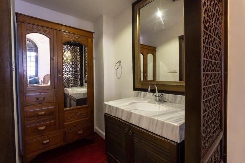 Hotel Puri Melaka في ميلاكا: حمام مع حوض ومرآة كبيرة