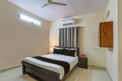 a bedroom with a bed and a ceiling fan at Super Collection O Sri Nirvana Edge in Hyderabad