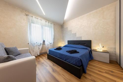 a bedroom with a blue bed and a couch at Verdemare in Duino