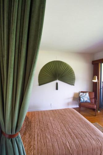 a room with a bed with a green curtain at The Lehua at Keauhou Bay in Kailua-Kona