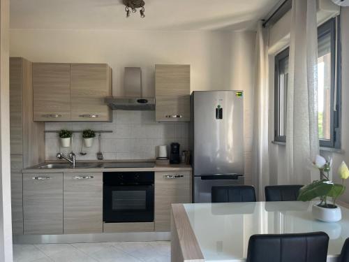 a kitchen with a refrigerator and a table with chairs at Lovely Apartment in Parma