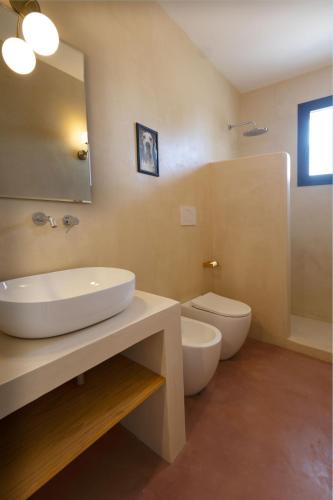 a bathroom with a sink and a toilet and a mirror at Al Poggiale - Residenza Mediterranea in Porto Cesareo